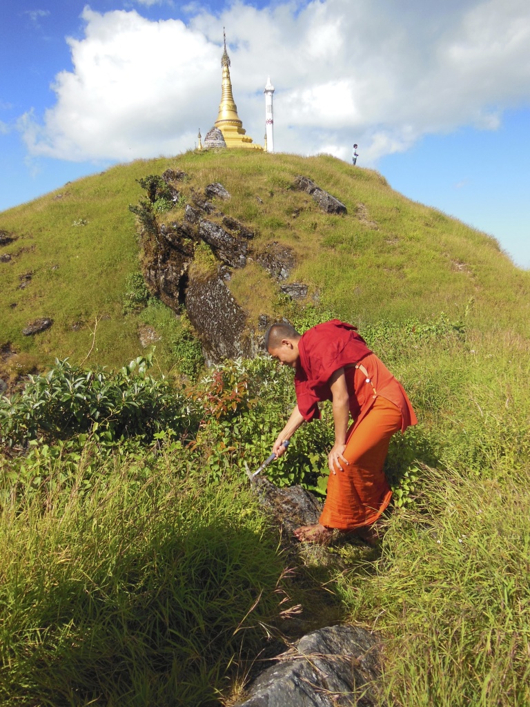 Monk geologist helping collect samples.