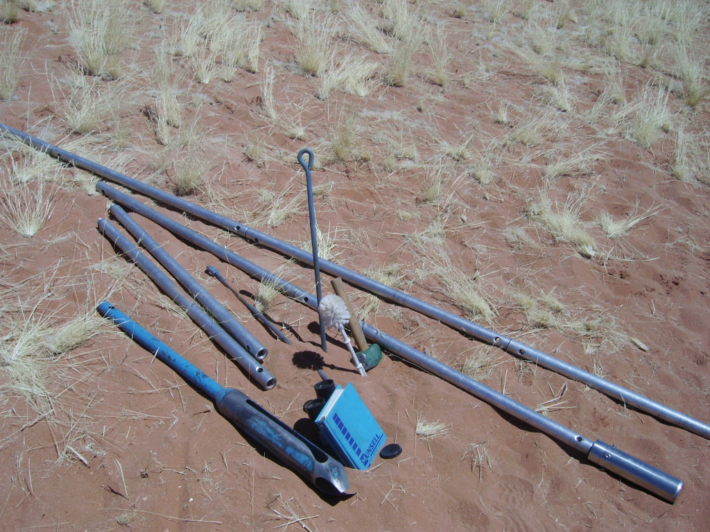 Photo 13: Augering kit, complete with accompanying hammer, Munsell colour chart and the infamous toilet-brush.