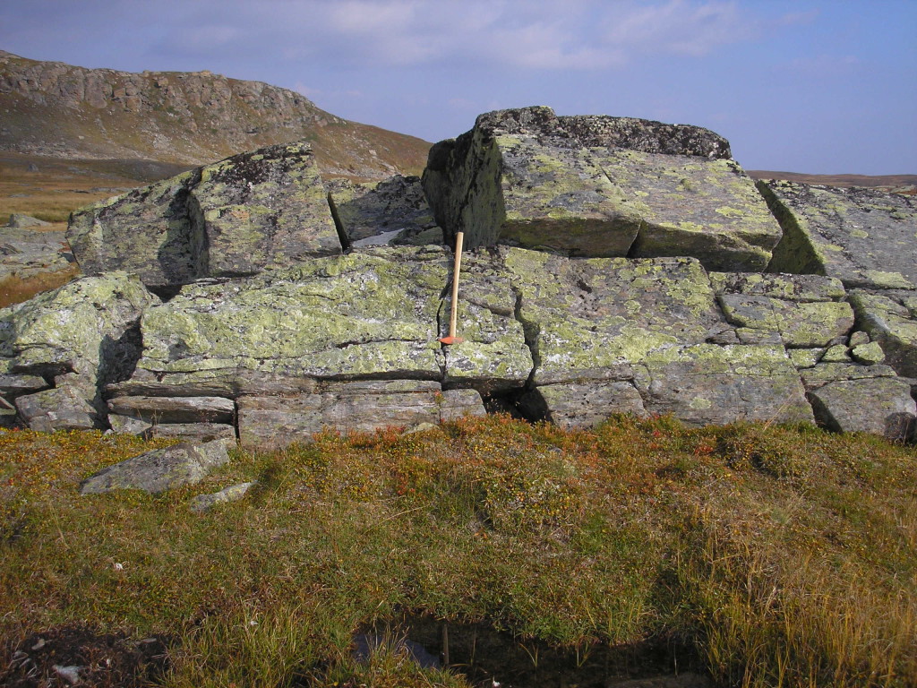 Fig. 2: Synkinematically intruded and deformed pegmatite vein in mylonitic high pressure garnet-micaschists of the continental Upper Seve nappe. Steep slope to the left is formed by massive and detrital serpentinites of the hangingwall oceanic Lower Köli nappe. Picture was taken close to the top of a 434-429 Ma extrusion wedge that exhumed high-pressure Seve nappes from mantle depths to mid-crustal levels.