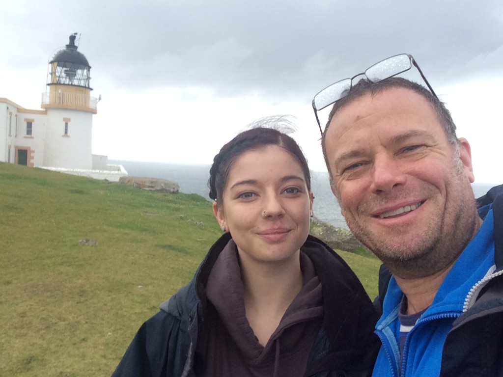 Fig. 6 – The author (right) and eldest daughter (central) and Stoer lighthouse (back left). The Stac Fada deposit is some 5 km behind the lighthouse and to the left (southeast).