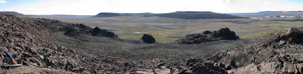 View of three volcanic vent necks preserved as erosional outliers among the adjacent flows and surrounded by deposits of loose scoria.