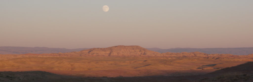 View from camp: moon rises over butte.