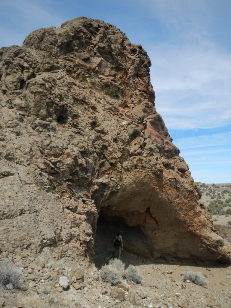 Dr. Mariek Schmidt (bottom) examines the roof of a cavity in a tuff outcrop in the Black Hills.