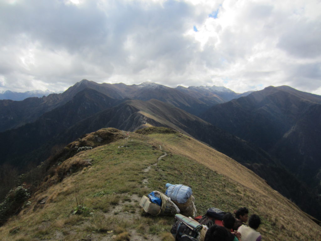 Photo 10: Taking a break at 4000 m, our high point in the center of the Karnali klippe. A snowstorm hit the nearby mountains overnight; we were lucky that our trail remained dry and that we could safely cross the pass. Rocks exposed here are part of the Tethyan sedimentary sequence that is in tectonic contact with the Himalayan metamorphic core along the South Tibetan detachment. They locally preserve north-verging folds such as those present left of the picture.