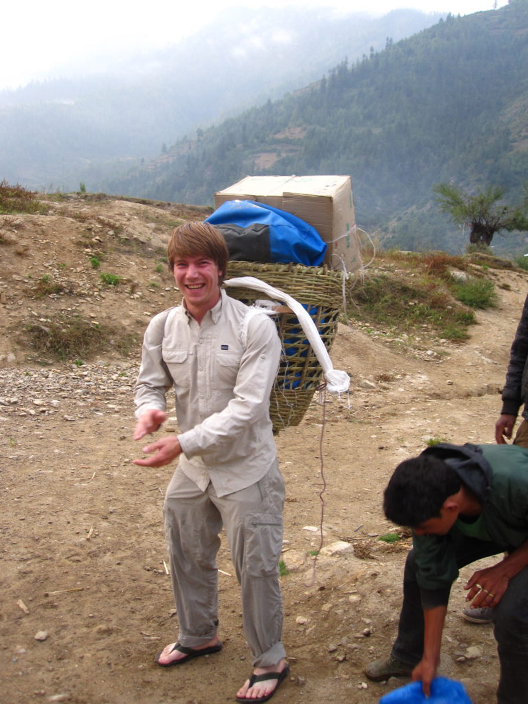 Photo 13: I tried to carry one of the dokos that the crew use to move our camp, but I couldn’t manage to use the head strap which carries most of the weight. Flip-flops are also part of some porters gear but that sure does not seem to slow them down when they run next to you on rugged terrain.