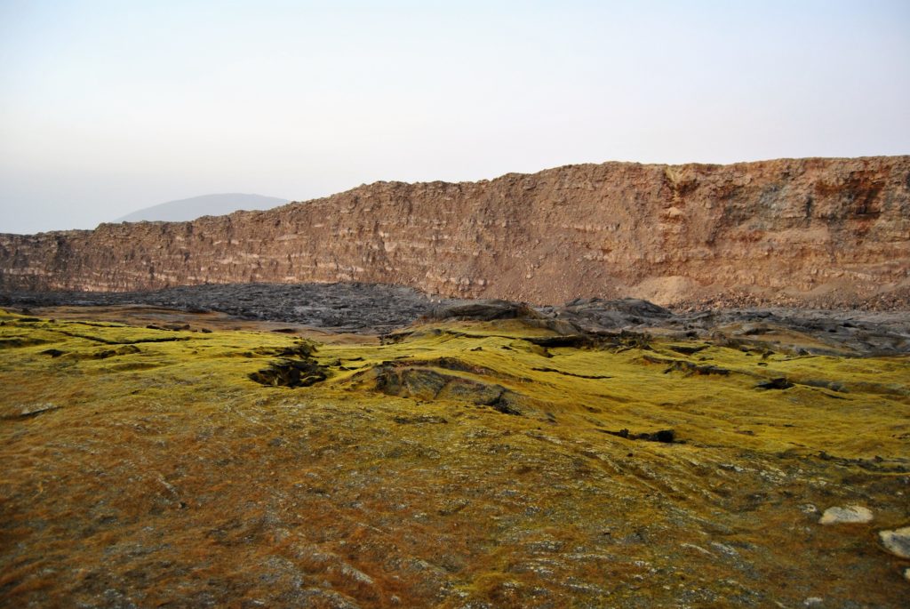 火山缝隙释放的含硫蒸汽结晶，形成了覆盖尔塔阿雷火山口的硫磺湖奇观，在日光下色彩绚丽。